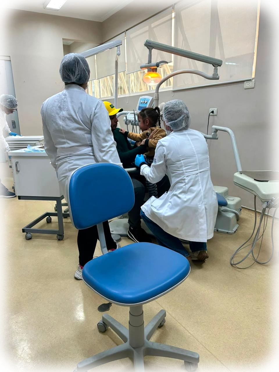 Equipe da Travessia atendendo uma paciente na cadeira odontológica.