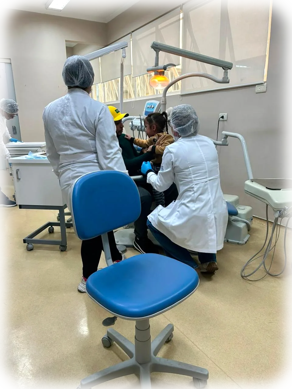 Equipe da Travessia atendendo uma paciente na cadeira odontológica.